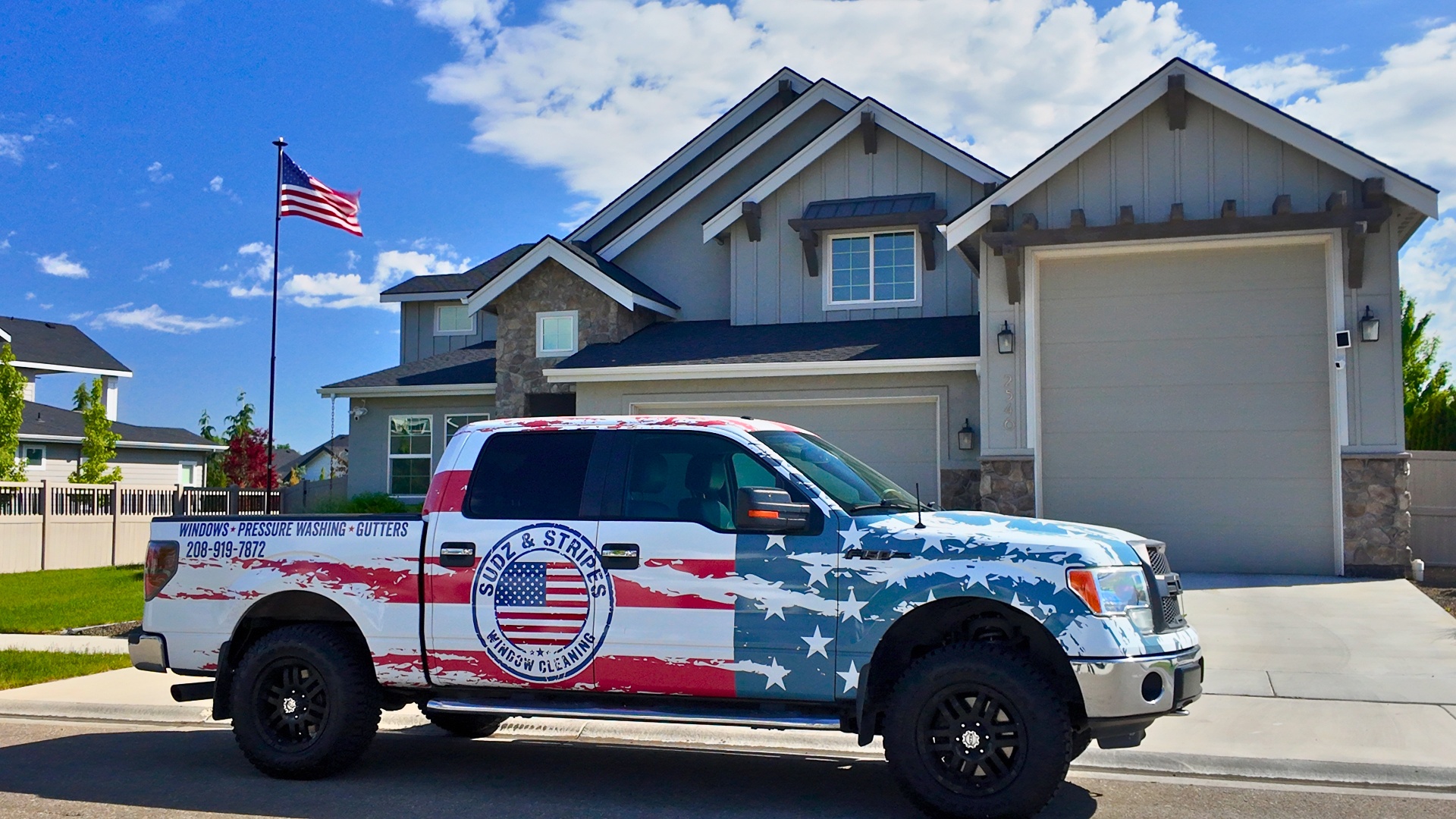 Sudz & Stripes American flag wrapped work truck parked in front of a Meridian Idaho home
